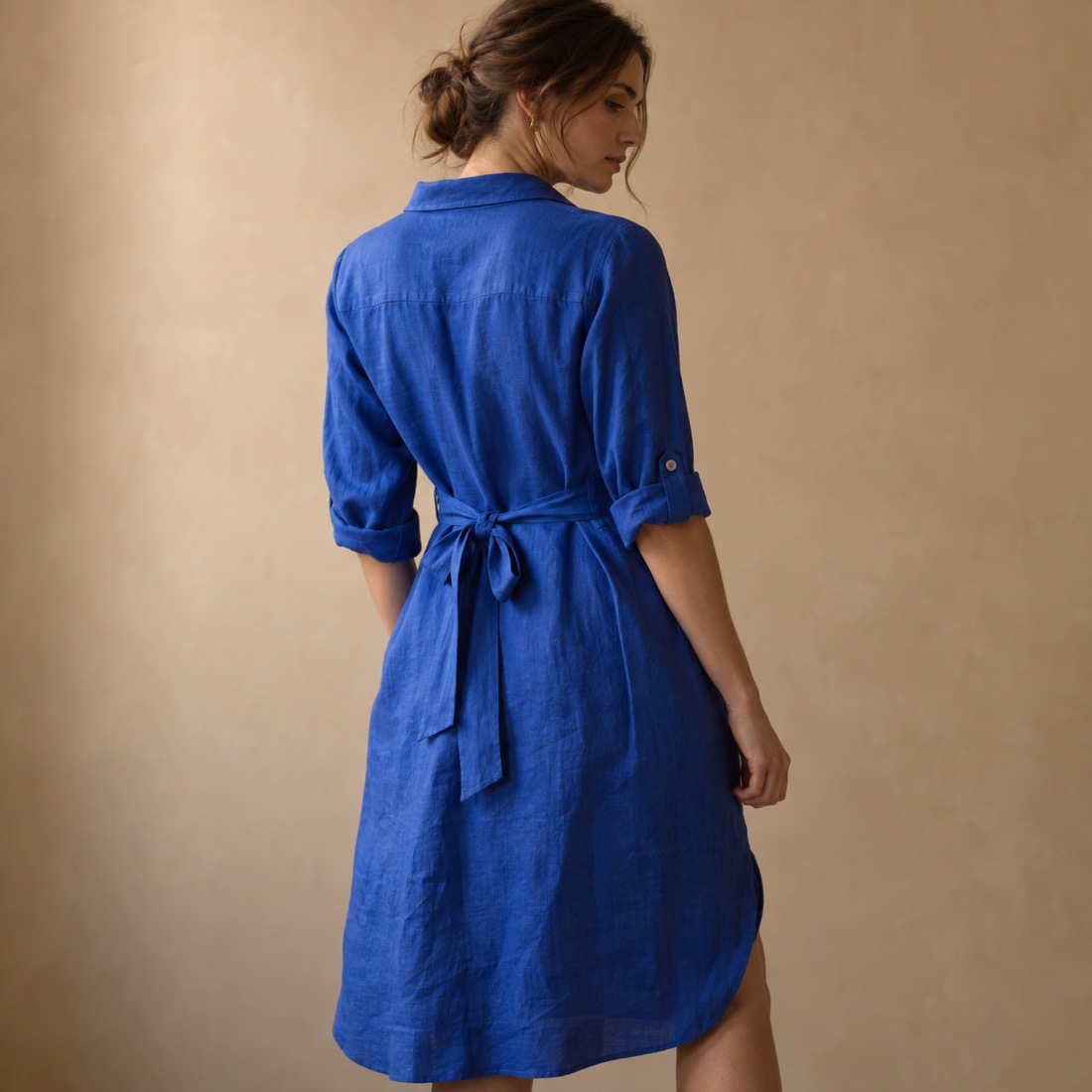 Studio photo of the same blue linen shirt dress worn by a model